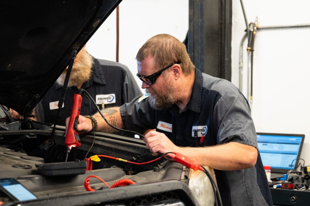 Technician testing a battery and charging system
