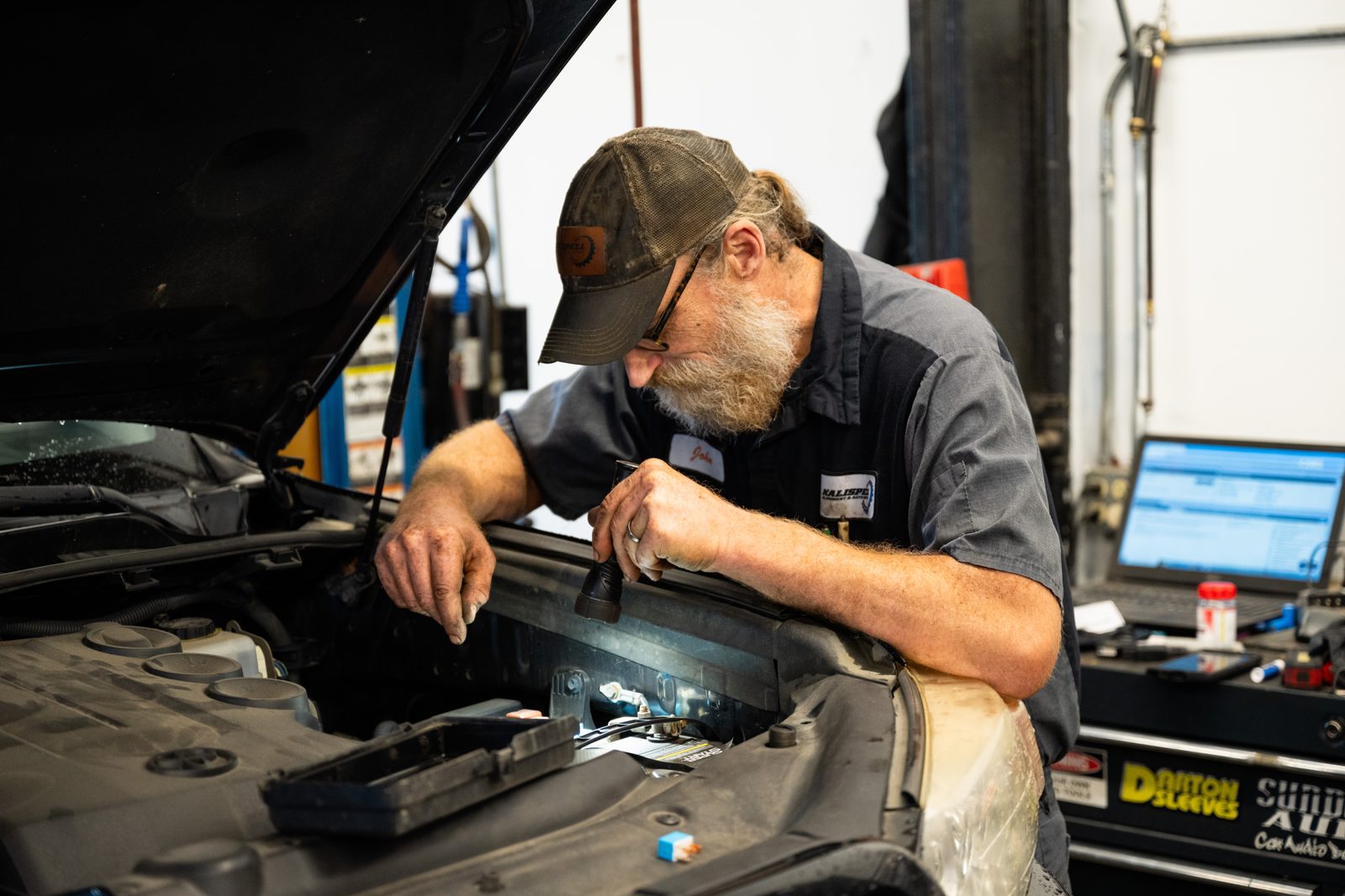 Technician running engine diagnostics with a laptop