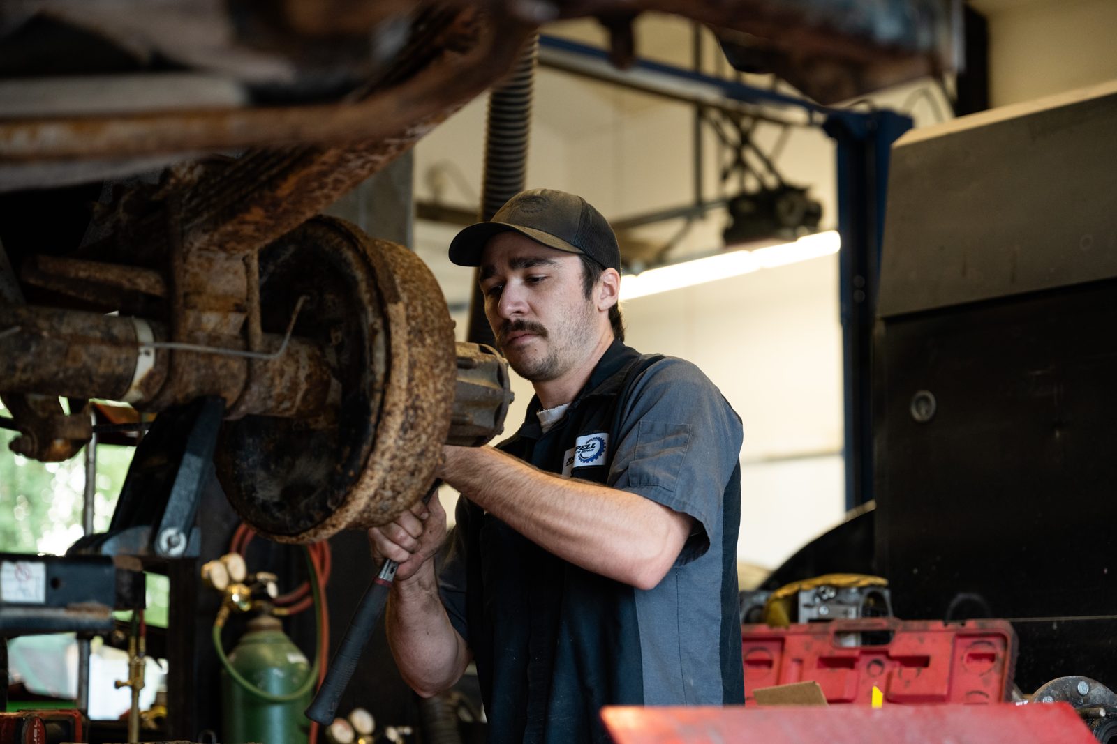Technician inspecting a brake assembly under a vehicle