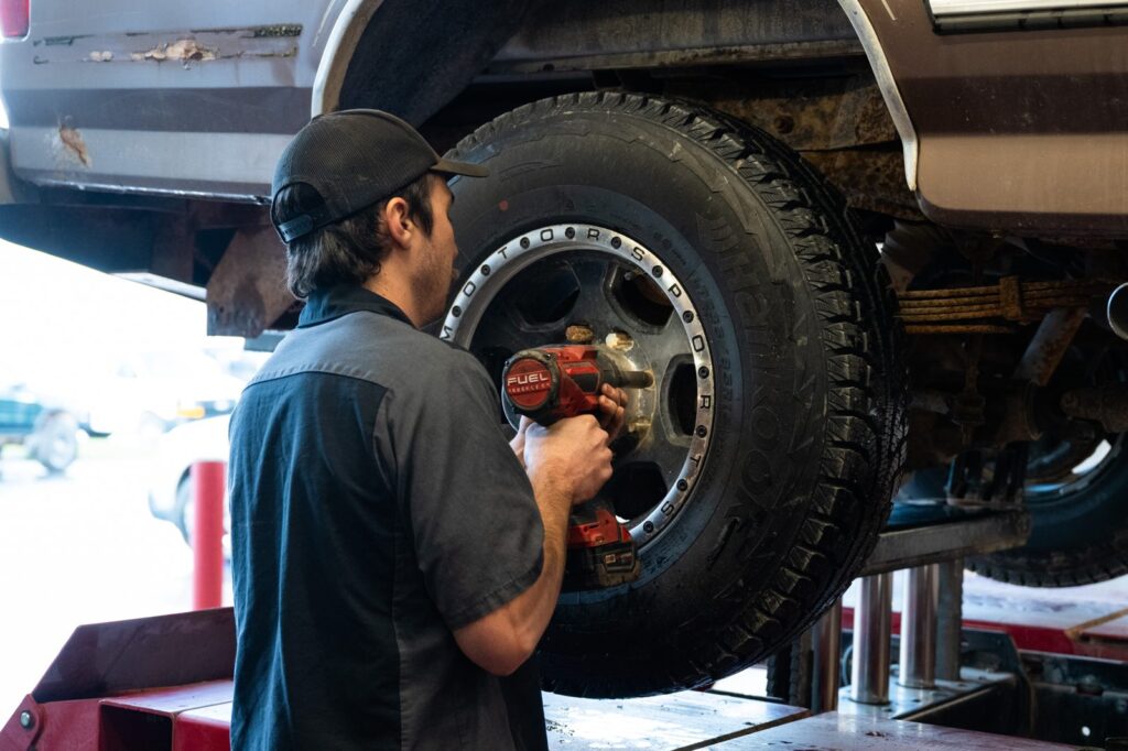Technician removing a wheel with an impact wrench